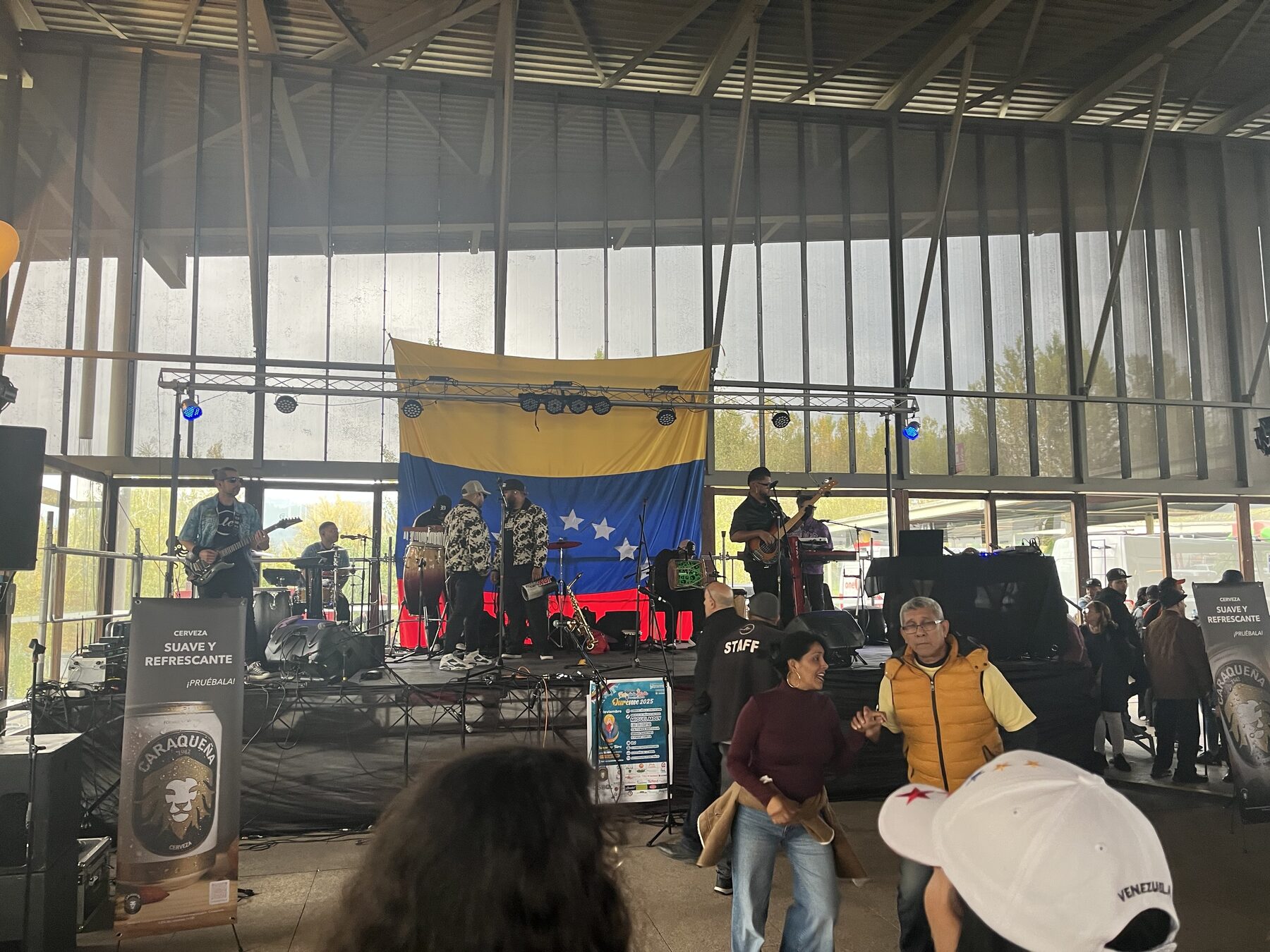 Actuación musical en la Feria de la Chinita de Ourense, con la bandera venezolana como fondo del escenario
