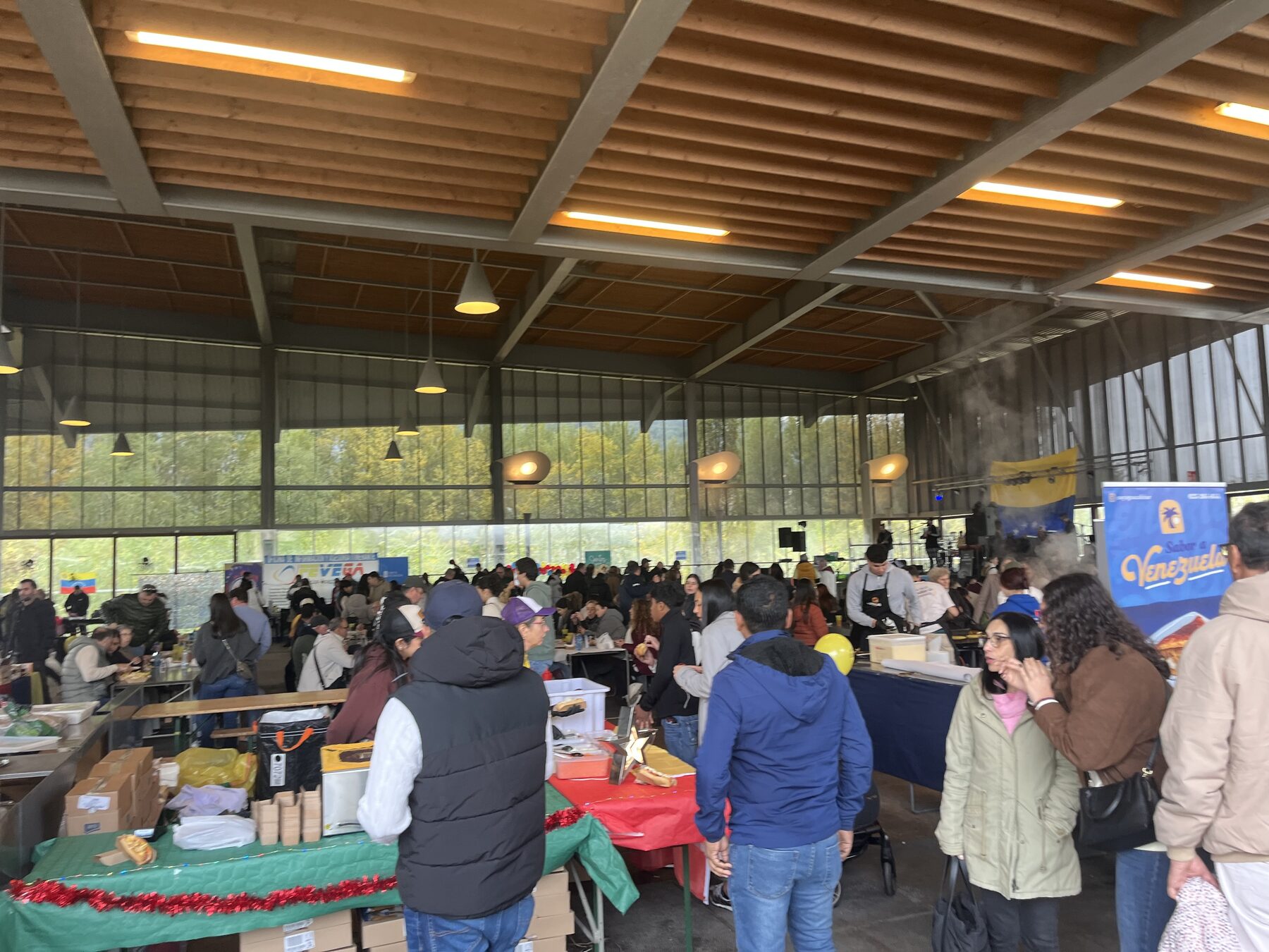 Vista general de la Feria de la Chinita en Ourense, con público, mesas de comida y el escenario al fondo